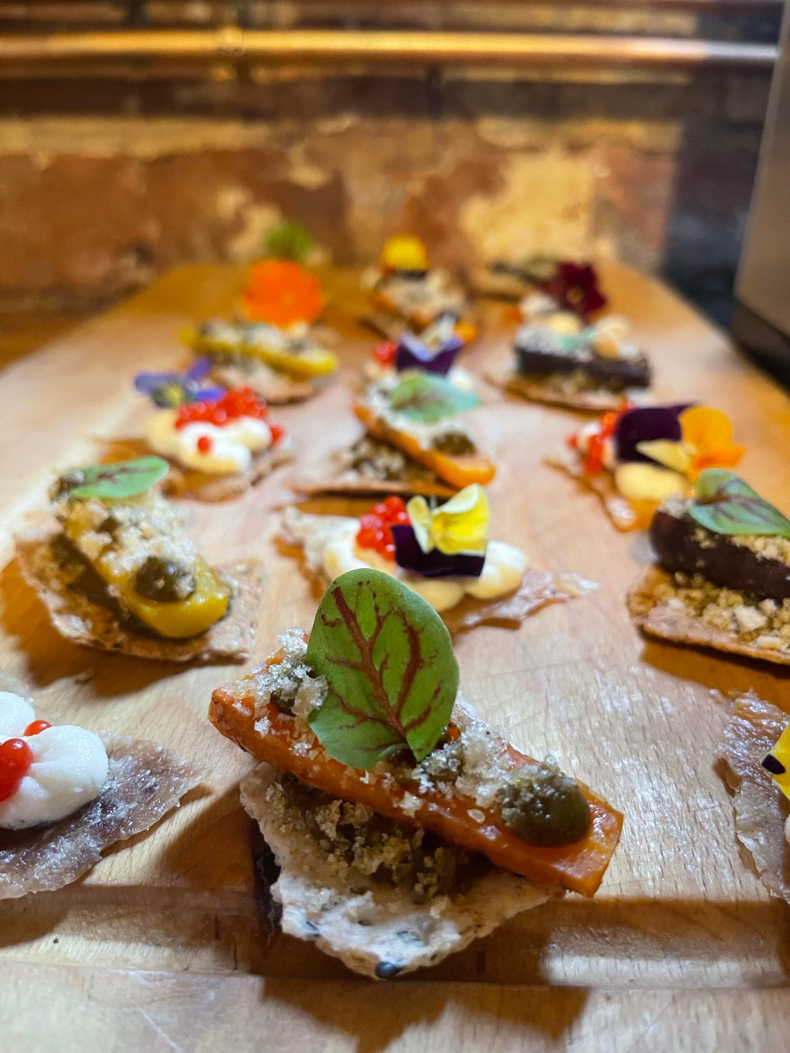 Canapés - roast baby heritage carrot and crispy chicken skin with ricotta and red pepper caviar